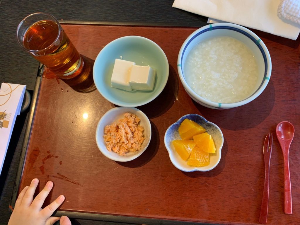 朝食時の離乳食（豆腐、おかゆ、鮭のほぐし身、オレンジ）